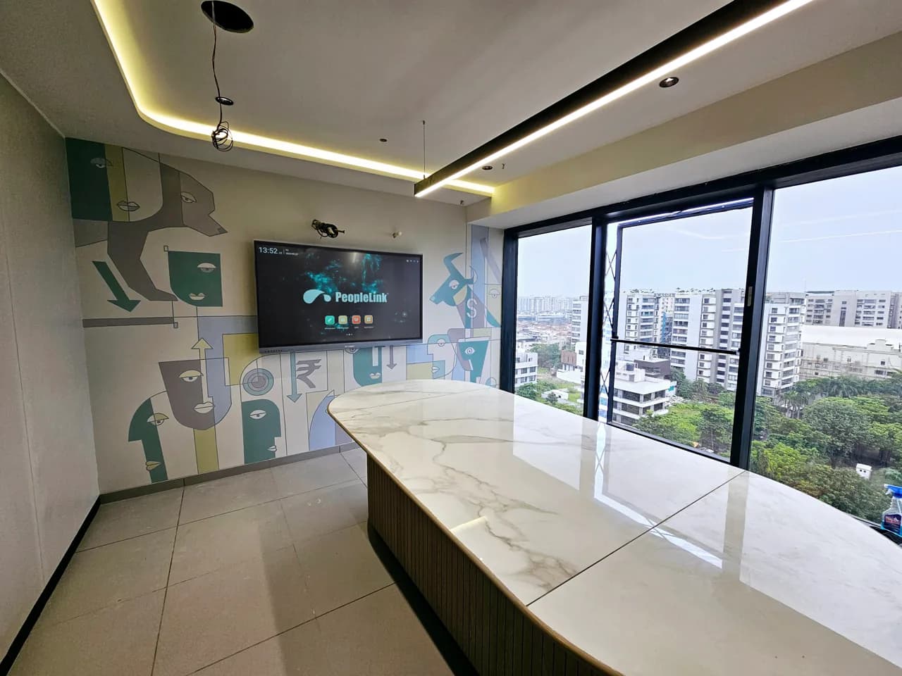 Executive boardroom with marble table, city view and wall-mounted PeopleLink display