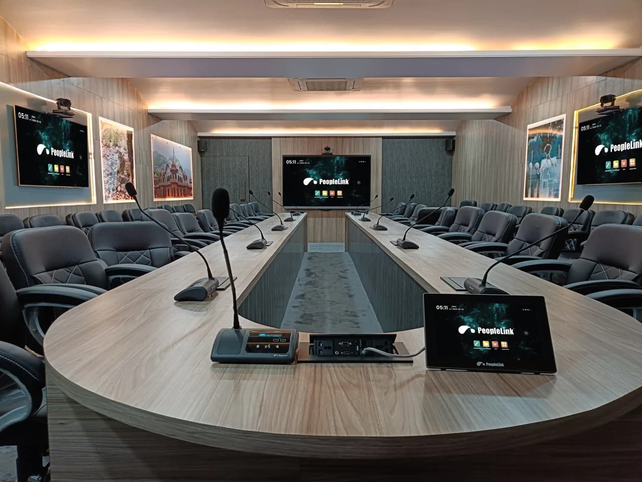Large council chamber with retractable table monitors and a wall display