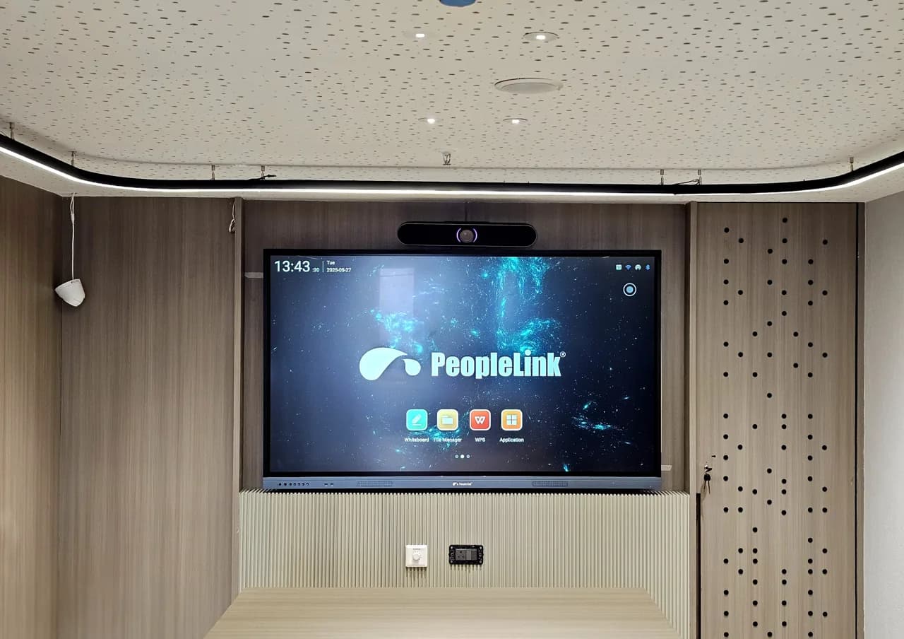 Interactive display with a 4K video bar mounted on a slatted wood wall in a meeting room