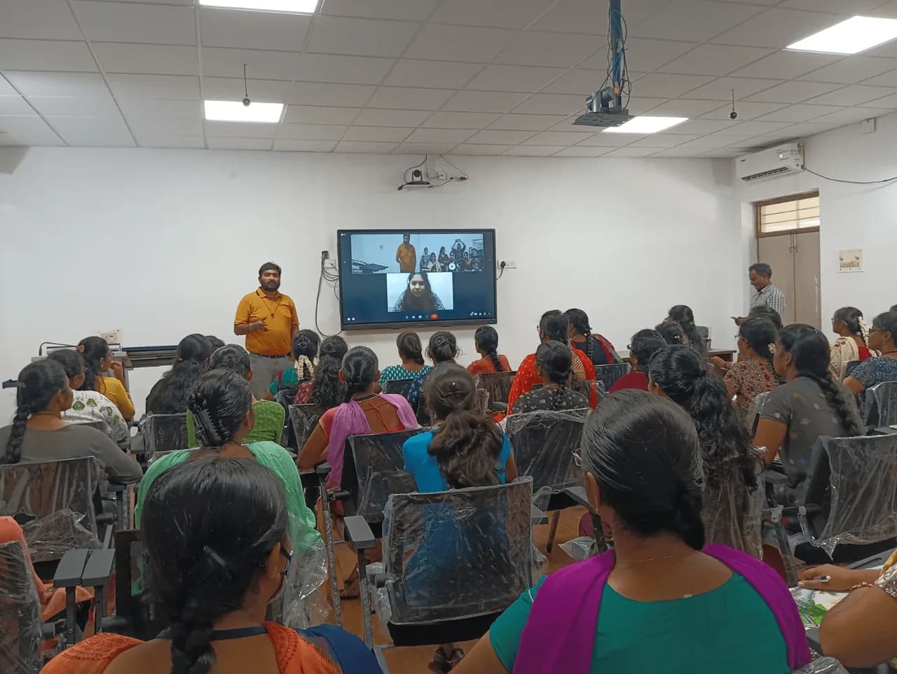 Classroom full of students with a trainer on a live video call